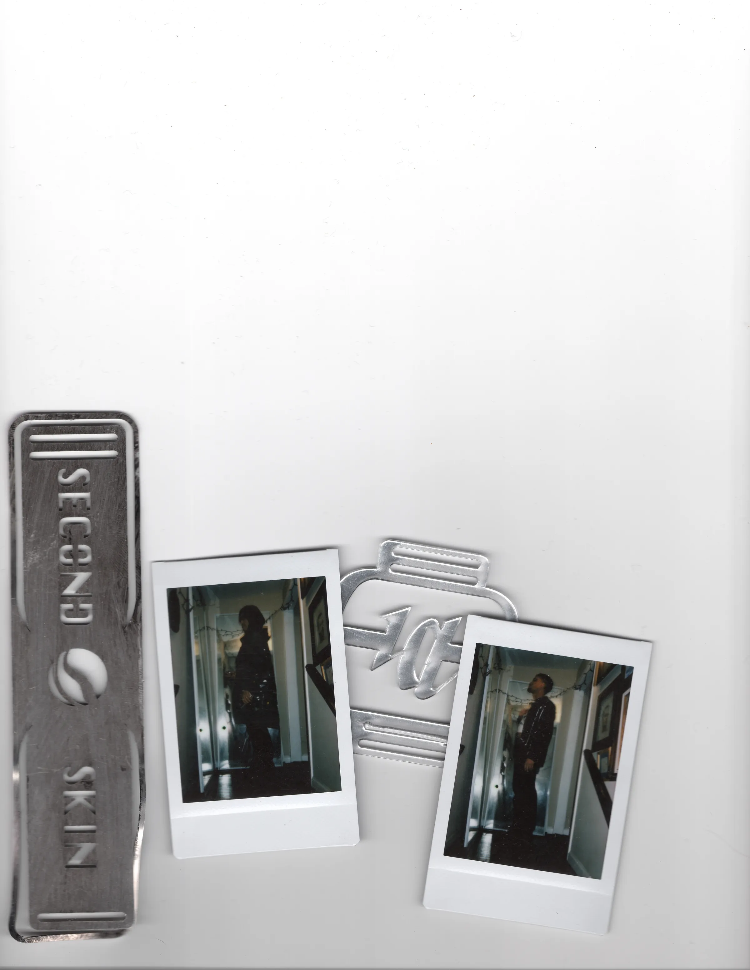 Metal Mersia hardware and two Polaroids arranged on a flatbed scanner.