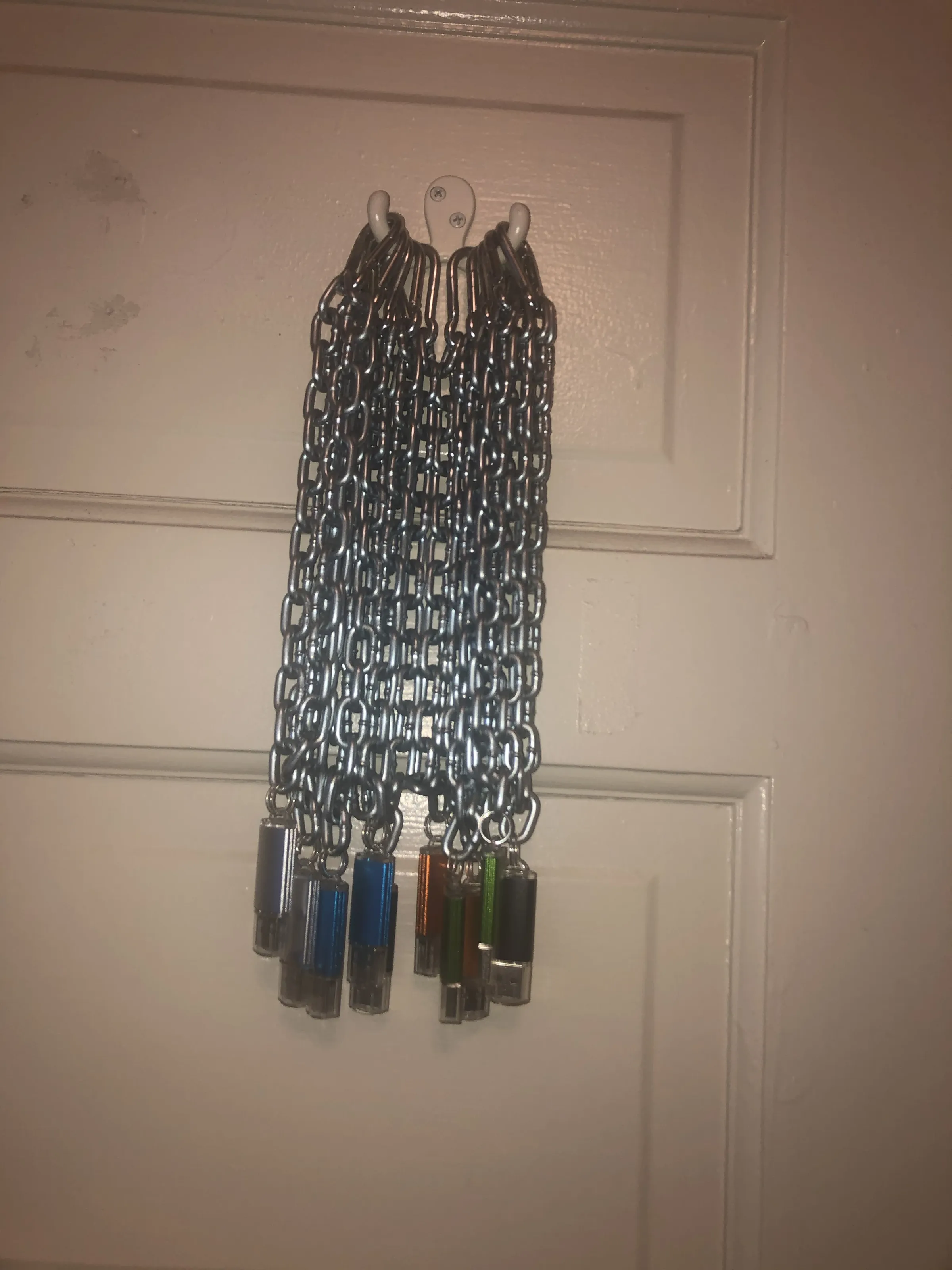 An inventory of chain-mounted USB drives hanging together on a door.